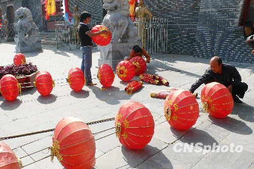 8月31日，河南省開封市天波楊府門口，工作人員在準備懸掛大紅燈籠。隨著“十一”國慶節(jié)和“十一”旅游黃金周的臨近，古城開封的公園景點已早早開始備戰(zhàn)，營造喜慶祥和的旅游環(huán)境，迎接八方客人。 中新社發(fā) 李俊生 攝