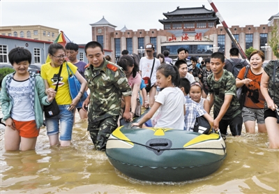 昨日，消防戰(zhàn)士在秦皇島市山海關(guān)火車站涉水運(yùn)送旅客。當(dāng)日，受持續(xù)強(qiáng)降雨影響，河北省秦皇島市海港區(qū)、山海關(guān)區(qū)等地出現(xiàn)內(nèi)澇，部分列車停運(yùn)。 新華社發(fā)