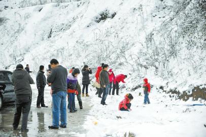 乘客在土山崗?fù)＼噮^(qū)休息時拍照賞雪。張磊攝