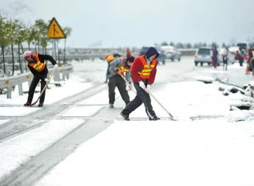 工作人員清理高速路上的積雪。 張磊攝