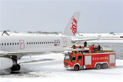 2月19日，南京祿口國際機(jī)場工作人員在清理飛機(jī)上的積雪。新華社發(fā)